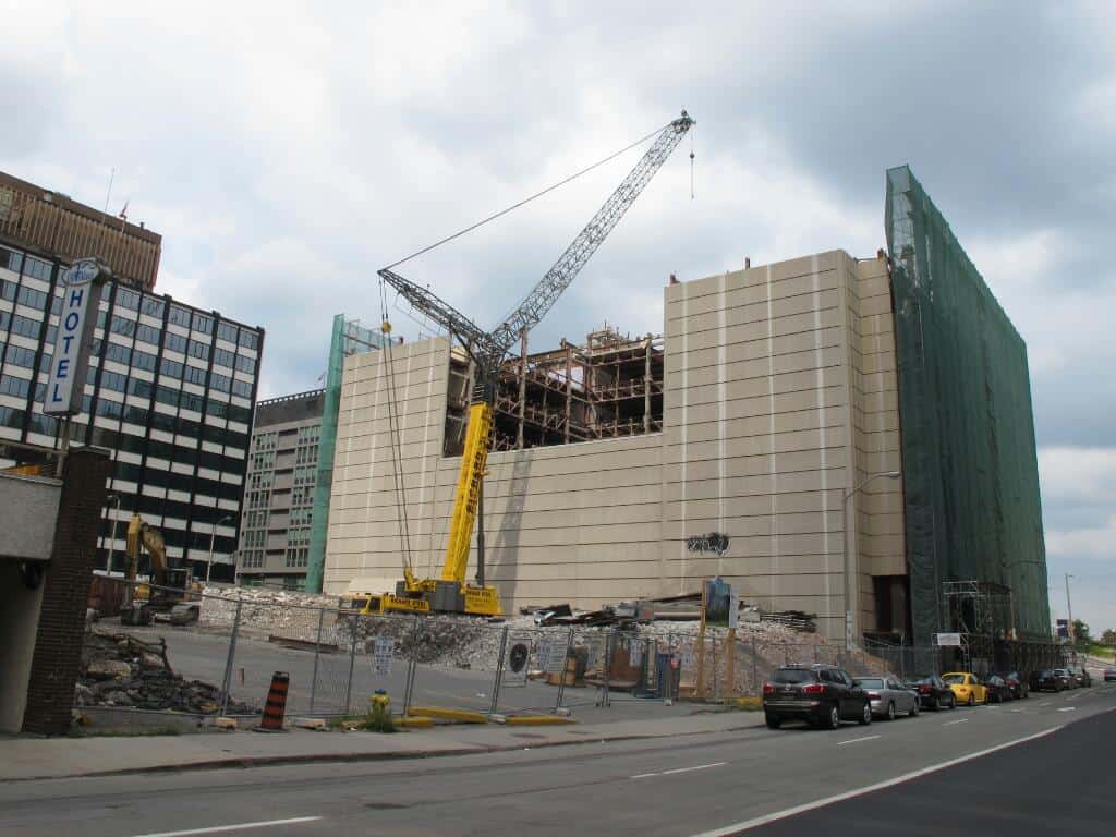 Crane perched to the west of the building awaiting more demolition debris