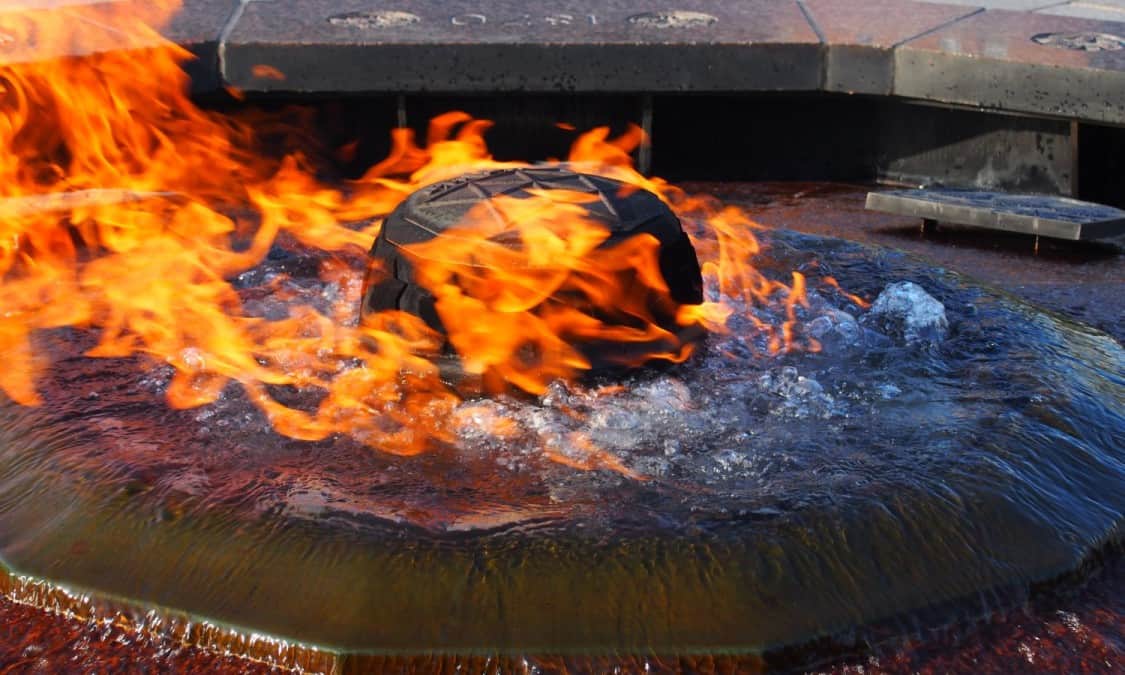 The flame burning through the water. The cap is emblazoned with the Centennial maple leaf