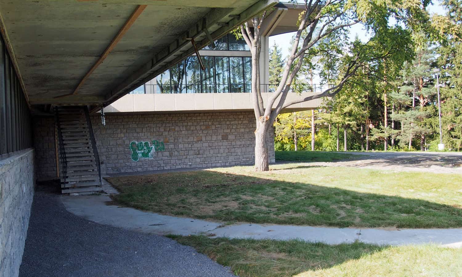 Looking towards the cafeteria wing under the outdoor terrace highlighting the limestone base