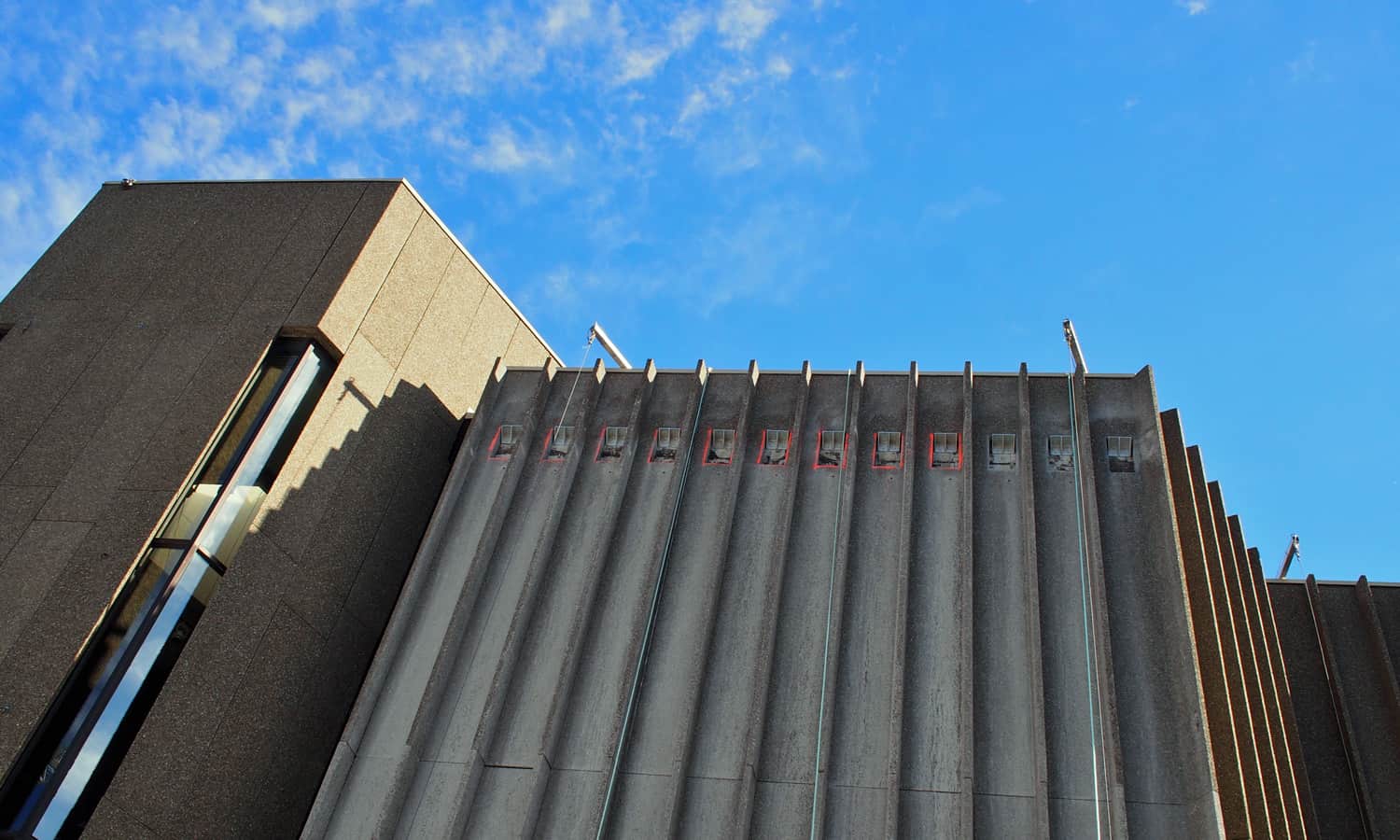 New metal angles being installed through holes cut into the precast panels on the north elevation